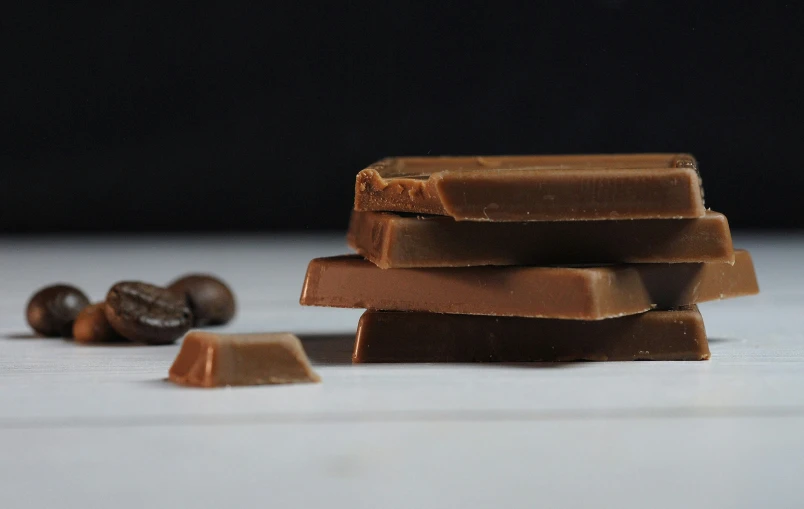 a pile of chocolate pieces next to almonds