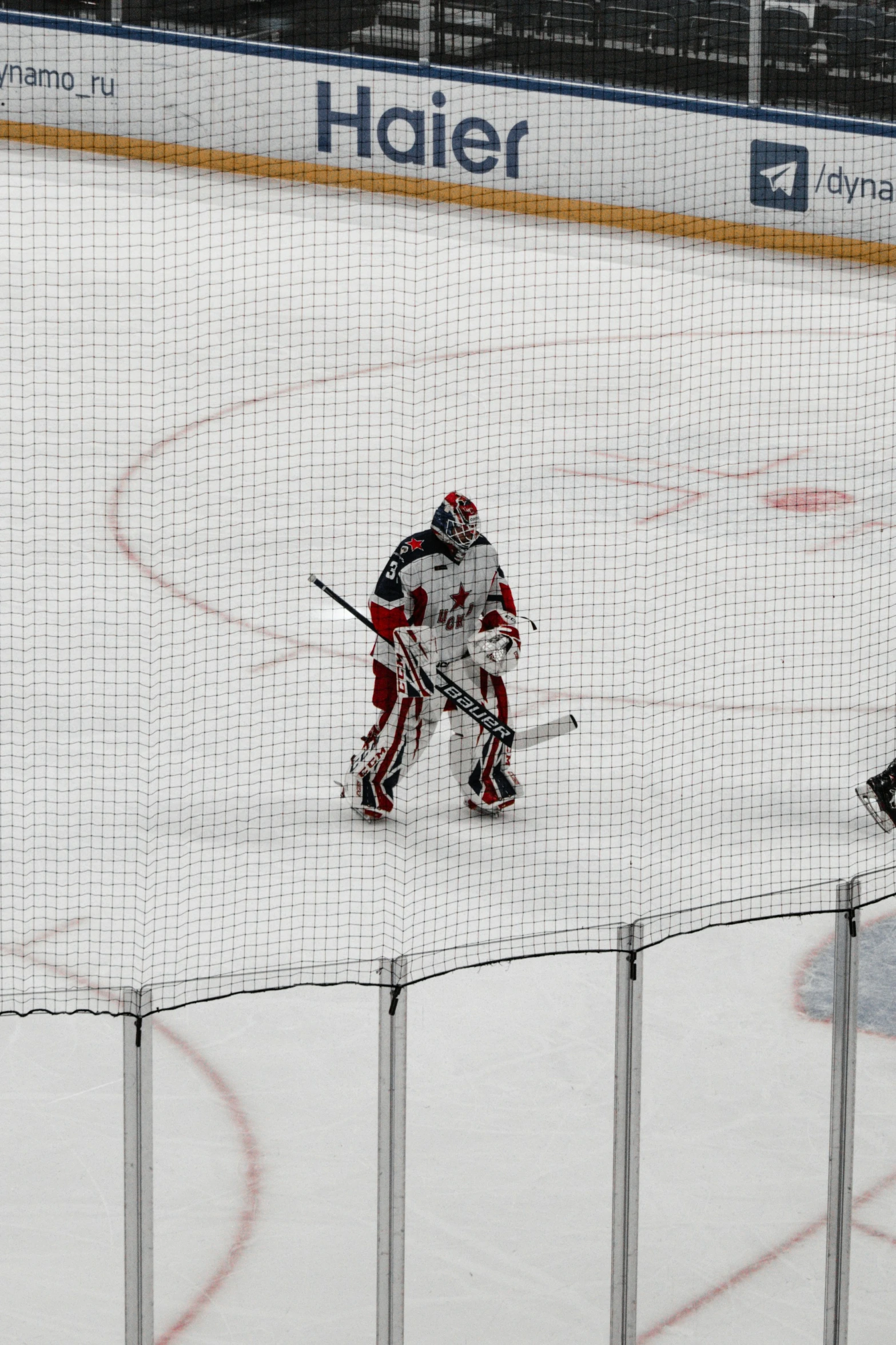 two ice hockey players in red and white uniforms play the puck