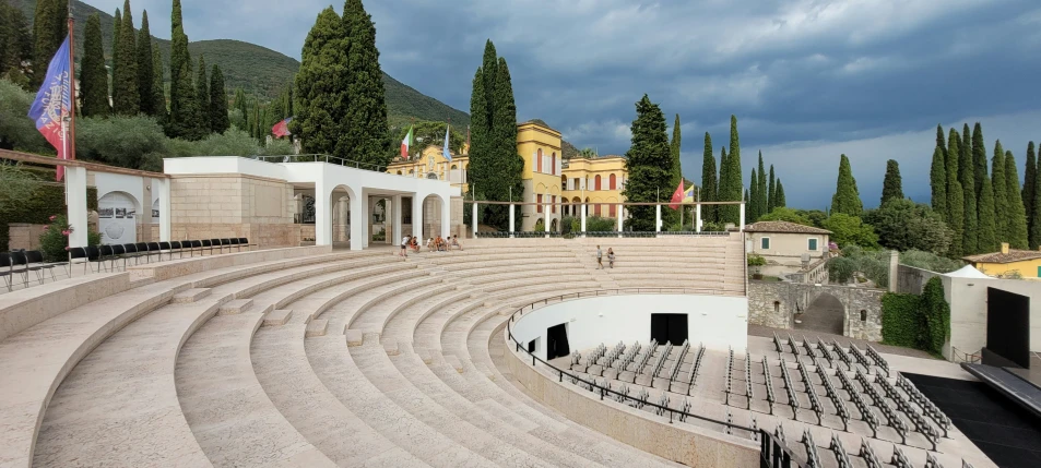 large stage with empty chairs surrounded by many trees