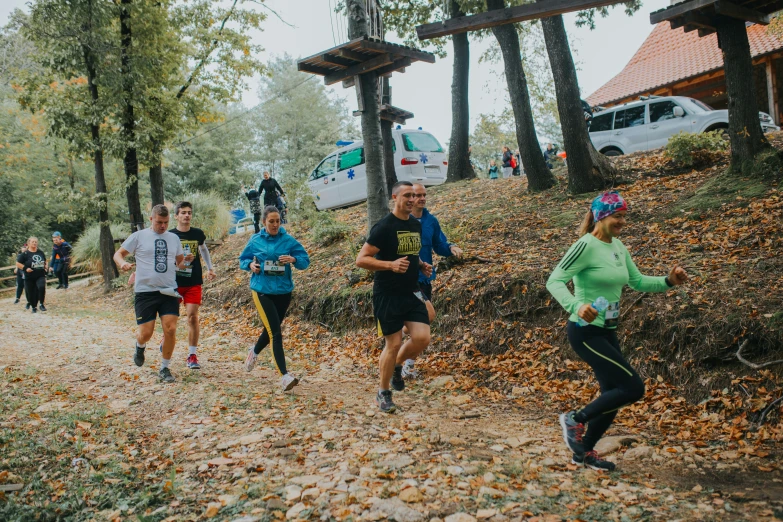 a group of people are running in the forest