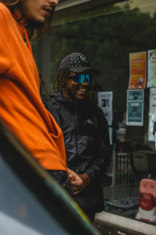 two men wearing sunglasses talking to each other