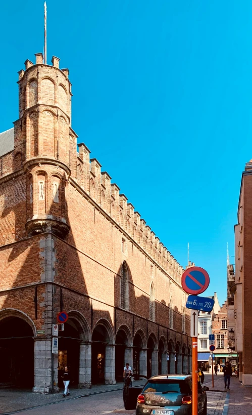 a large brick building is behind some cars