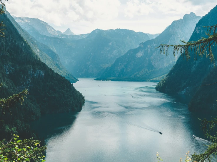 a body of water surrounded by hills and grass