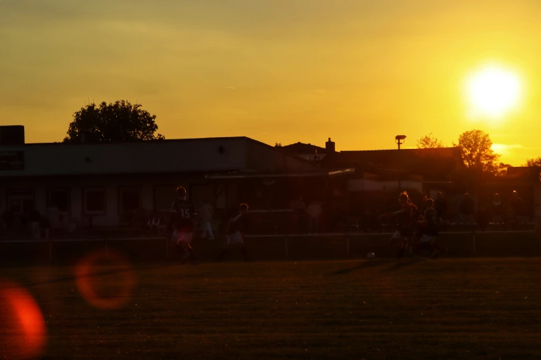 people are playing football at sunset or dawn