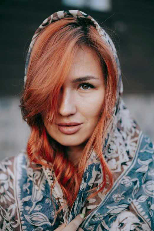 a woman with red hair and blue and white scarf posing for a picture