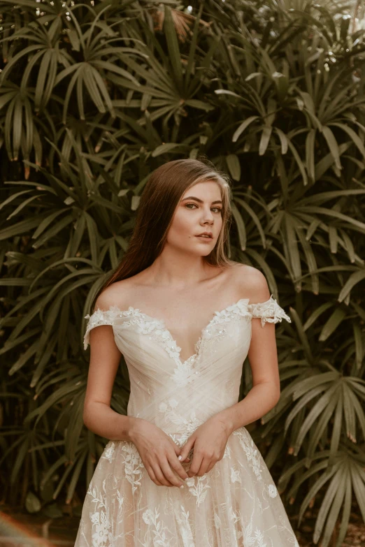 a beautiful woman in an off the shoulder dress and jewelry