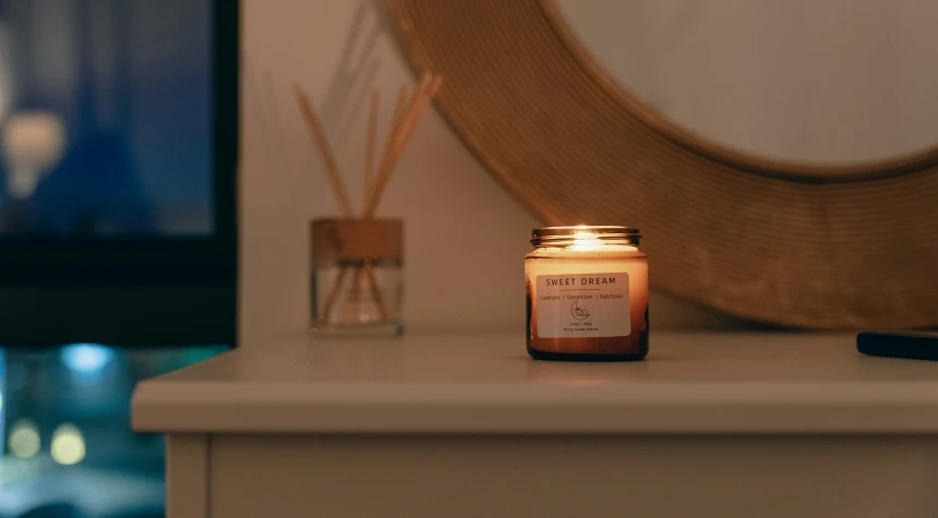 an orange scented candle sitting on a mantle