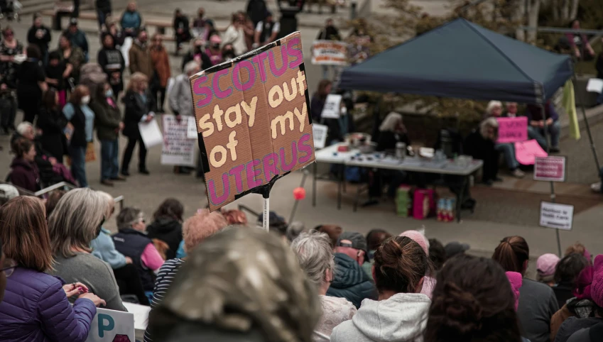 a woman holds up a sign in the crowd