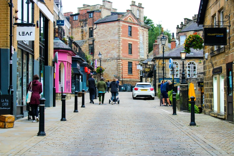 a paved road with people walking and shopping