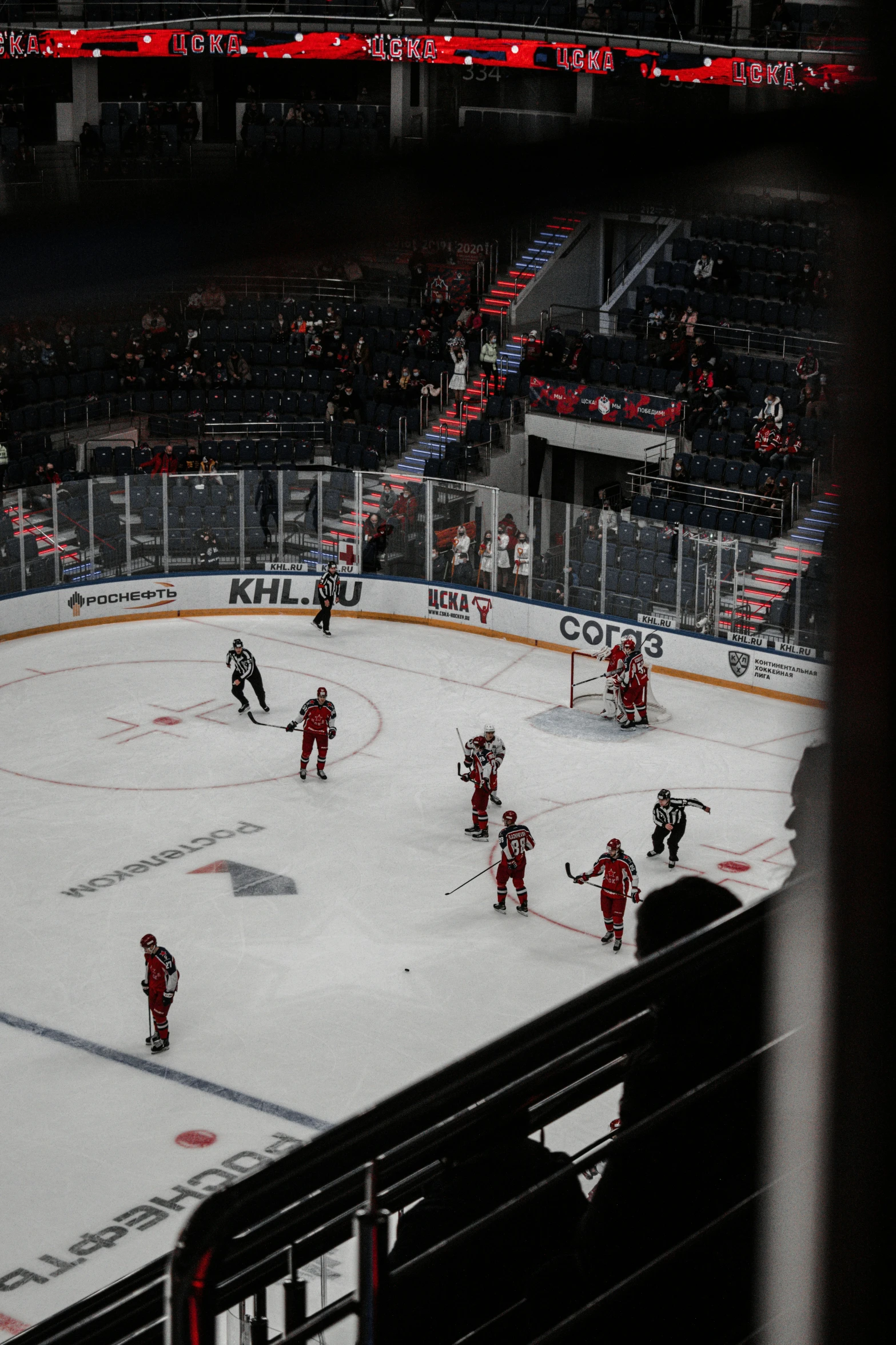 a hockey game on an ice rink with the referee directing the play