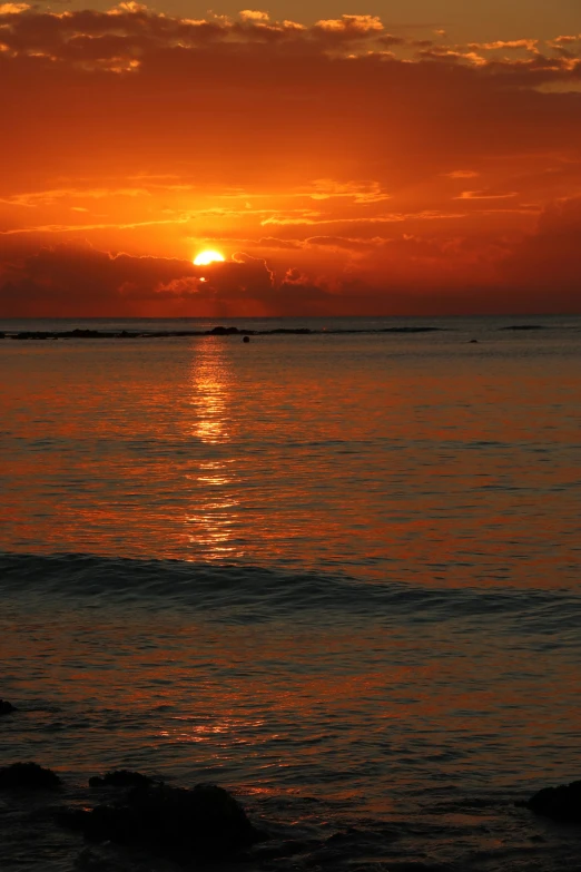 the sunset reflects on the water and the horizon