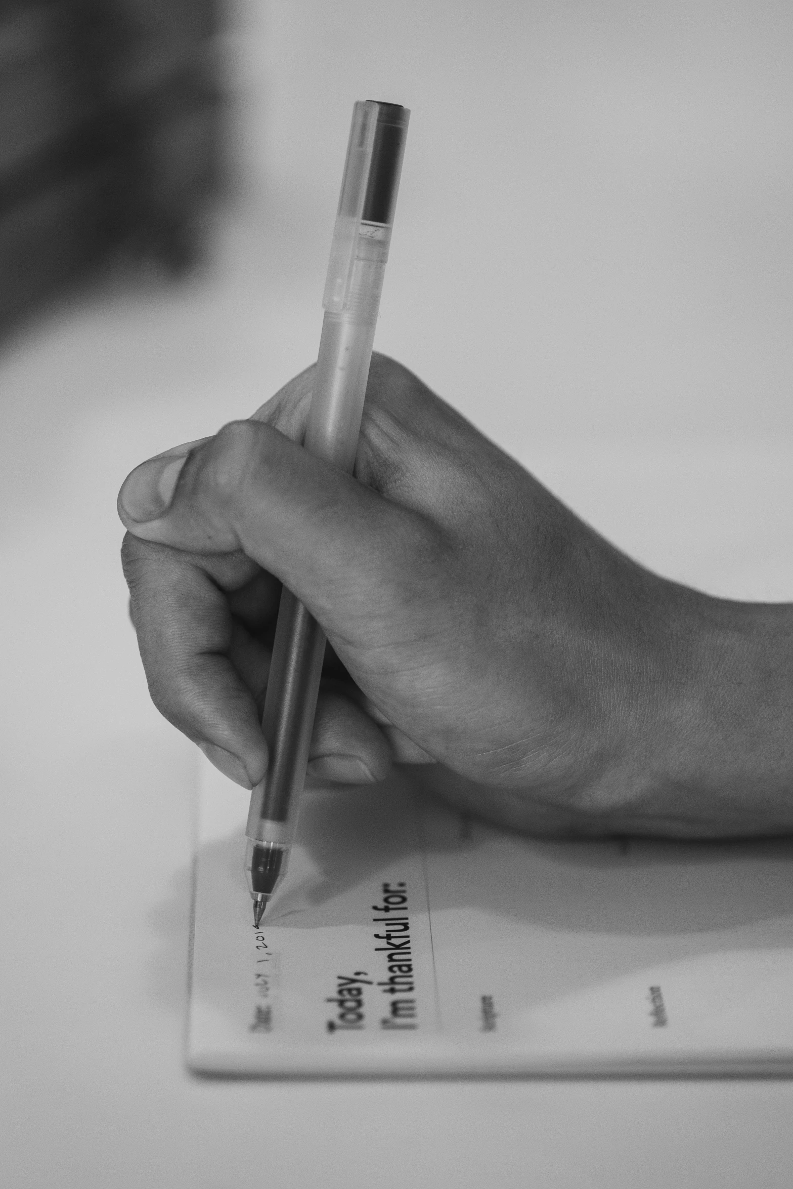 person writing on paper with a pen