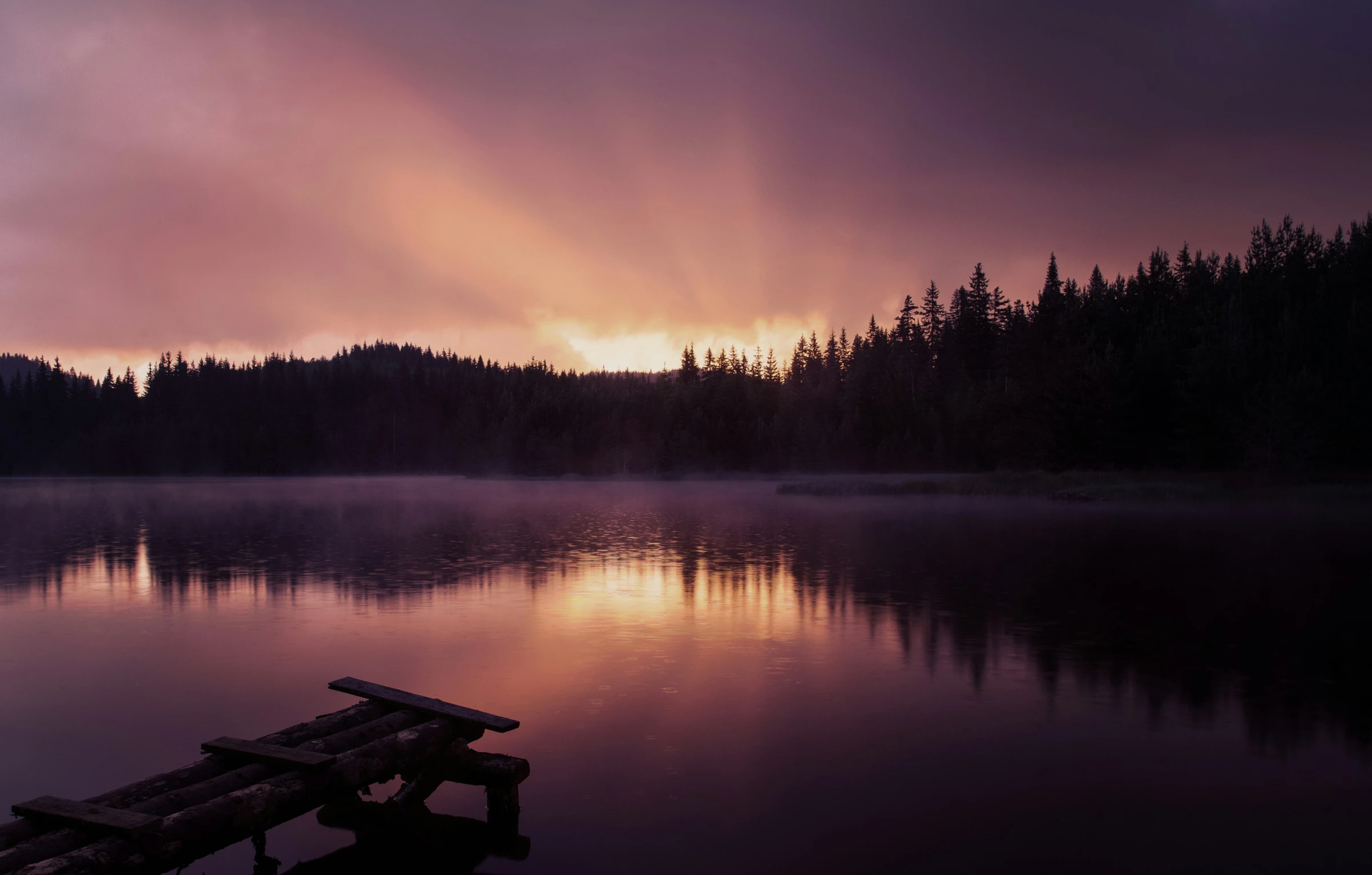 an image of the sun setting on a lake