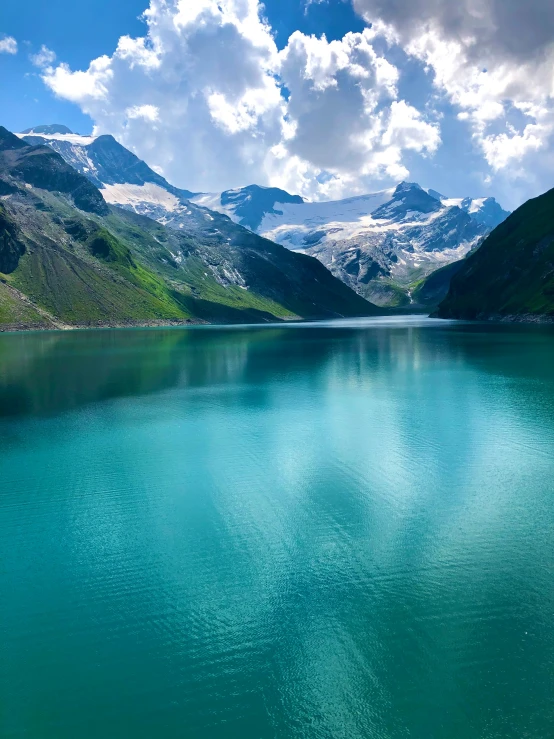 a boat sitting on top of a large lake surrounded by mountains