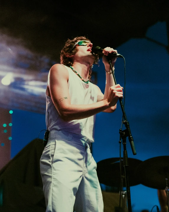 the young man is singing on stage with his microphone