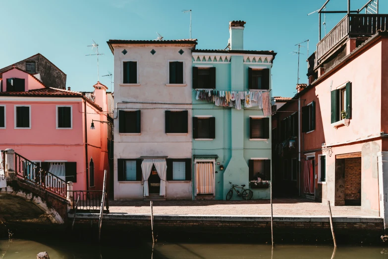 the house is colorfully colored and is beside the water