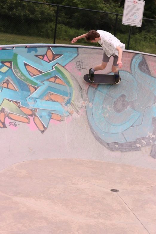 a boy is on his skateboard on the side of the ramp