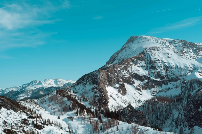 a snow covered mountain side and trees with snow on it