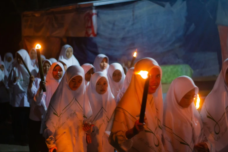 a group of nun women holding torches during a procession