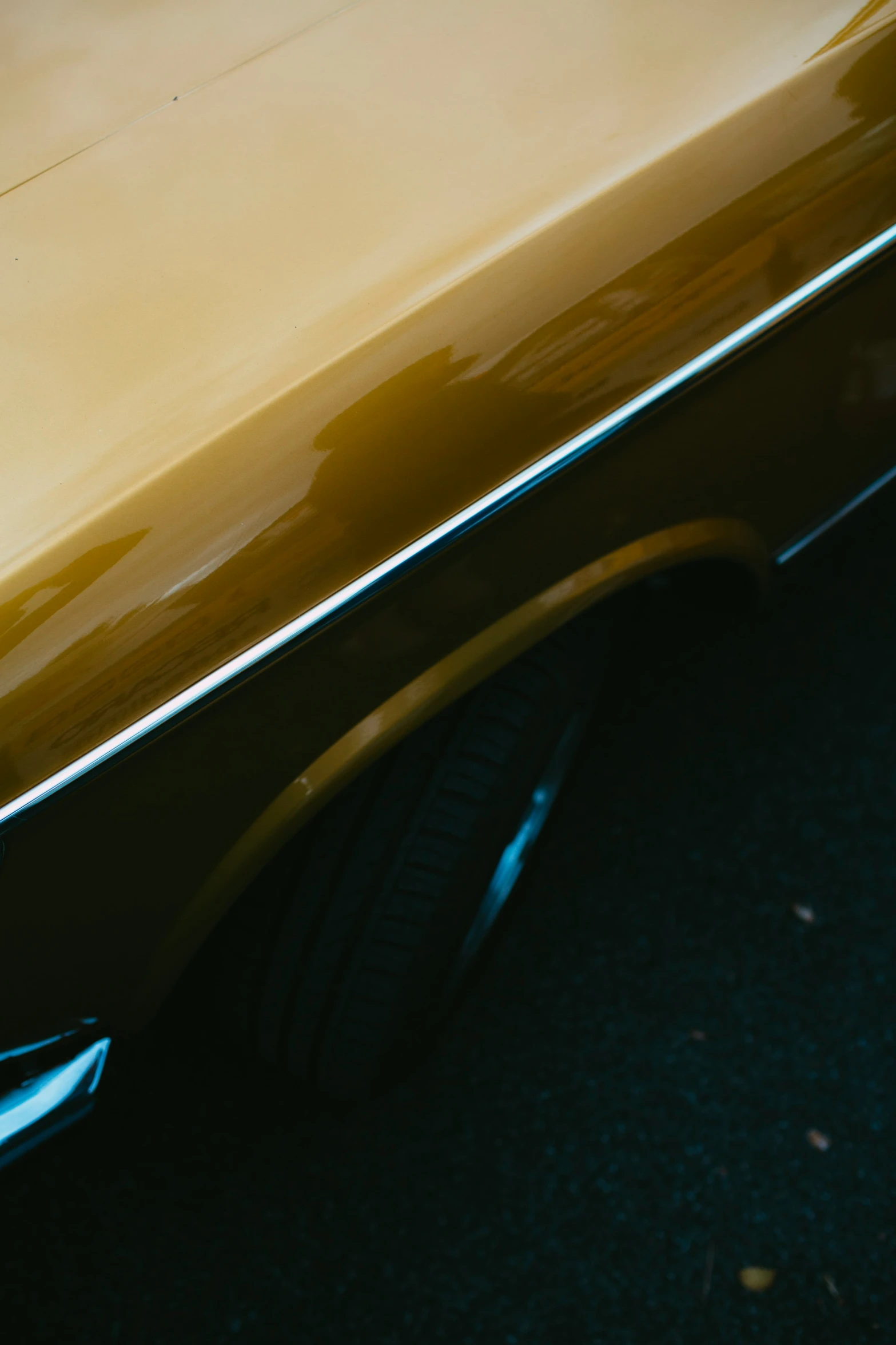 the gold car with a black top parked