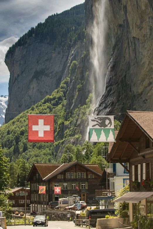 a mountain side town under a waterfall covered in snow