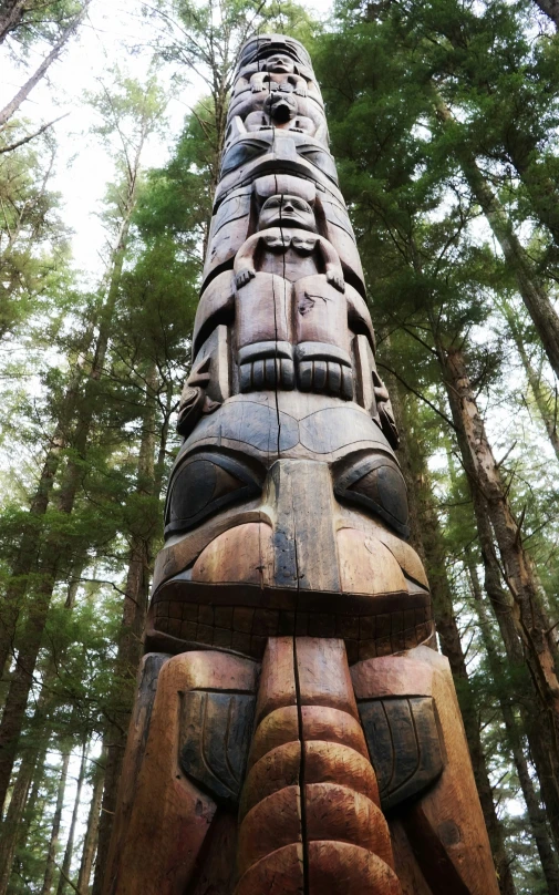 a very tall statue in the middle of a forest