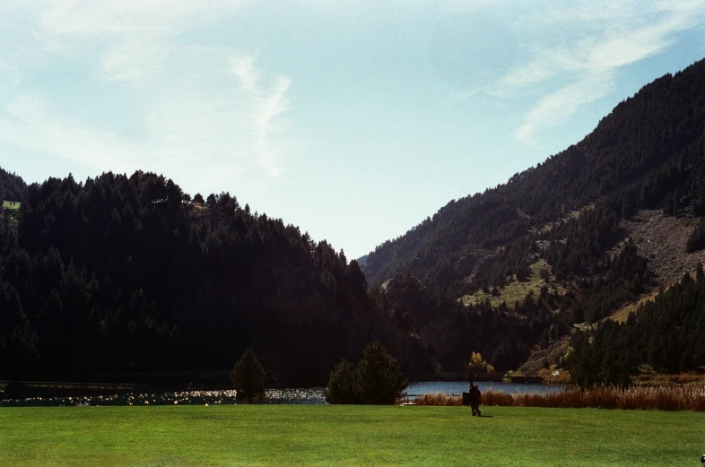 a very nice park that has grass and mountains around it