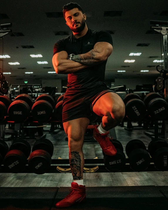 a male bodybuilder performs a squat at the gym