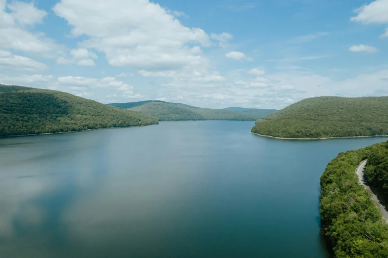 a body of water surrounded by green mountains