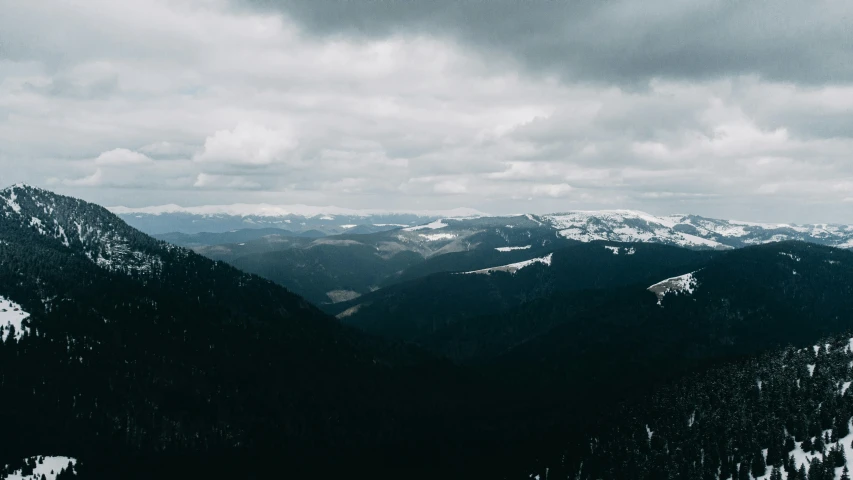 the clouds are gray over the snowy mountains