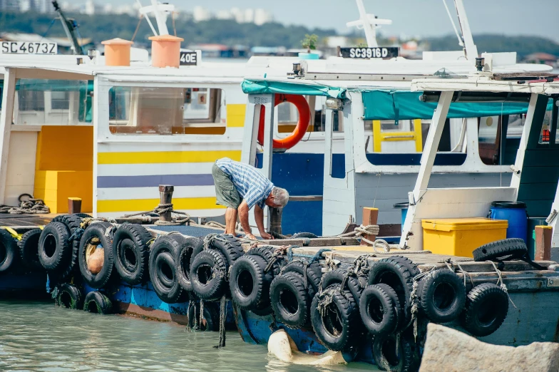 an old man picking up tire for boats