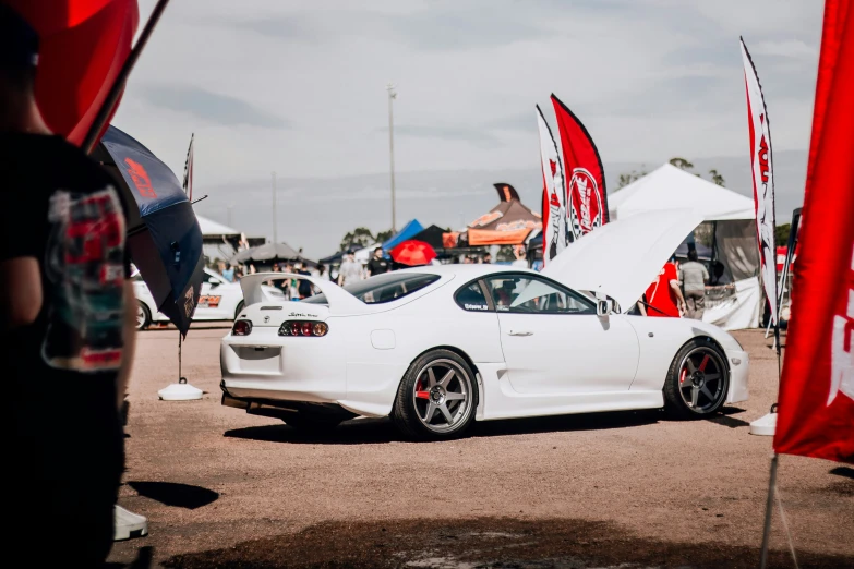 the white sports car is parked near other vehicles