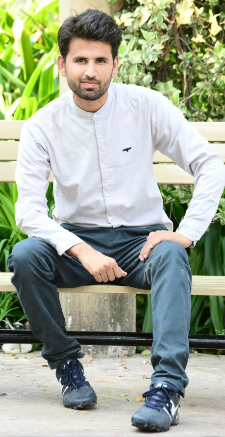 a man sitting on top of a wooden bench