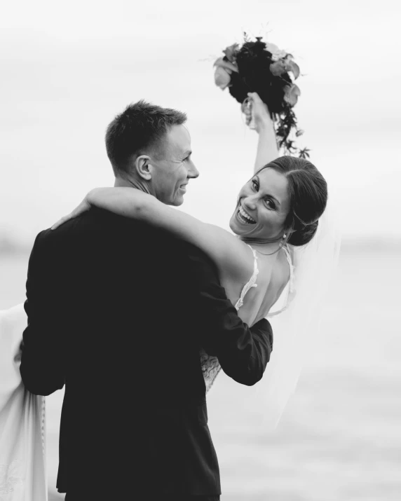 a woman standing next to a man holding a bouquet