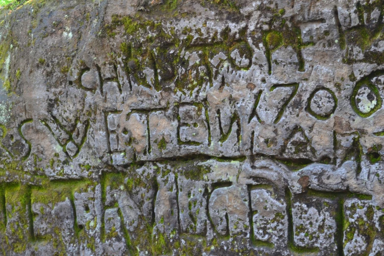 graffiti is on the side of a stone wall