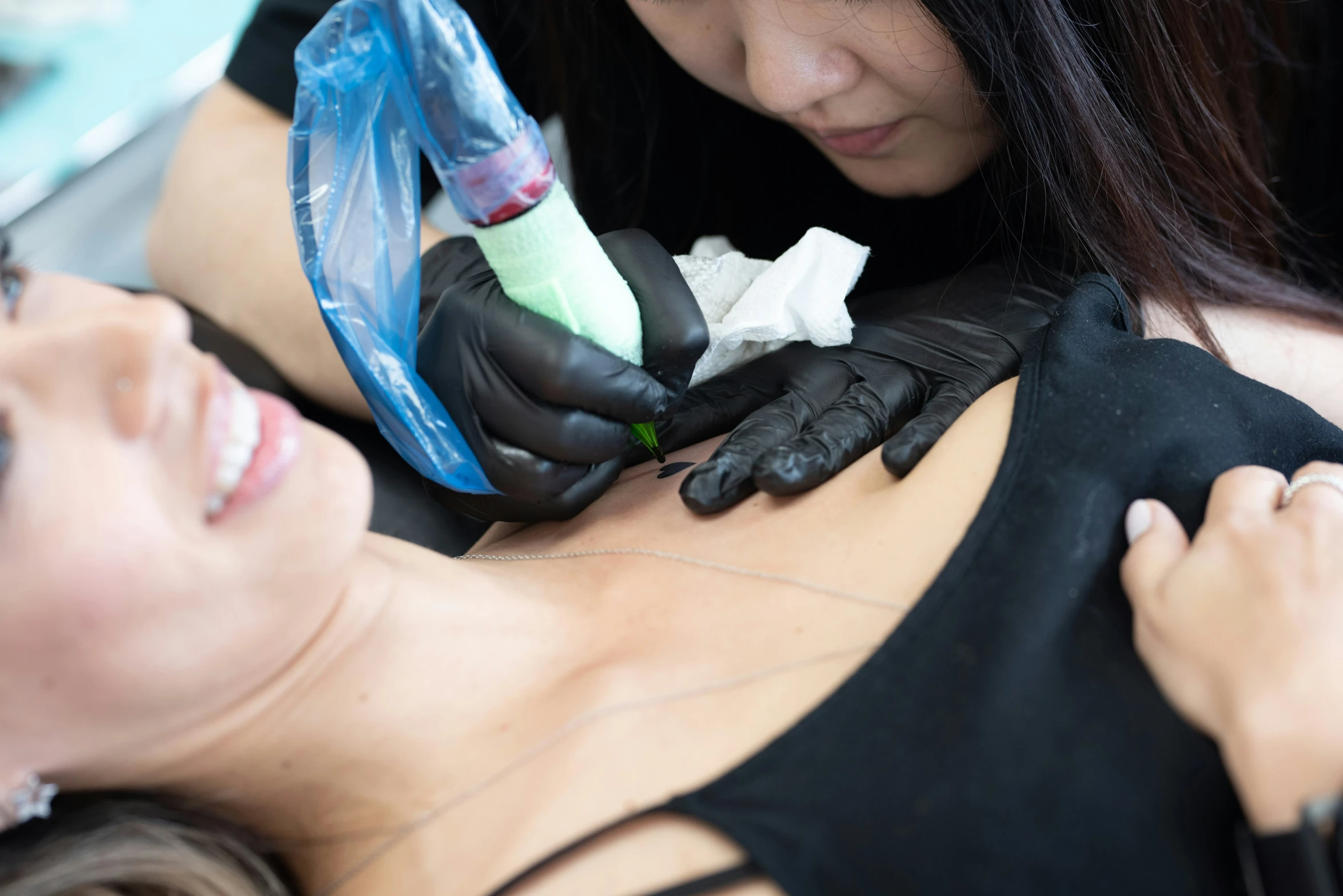 two people getting tattoos done by a woman