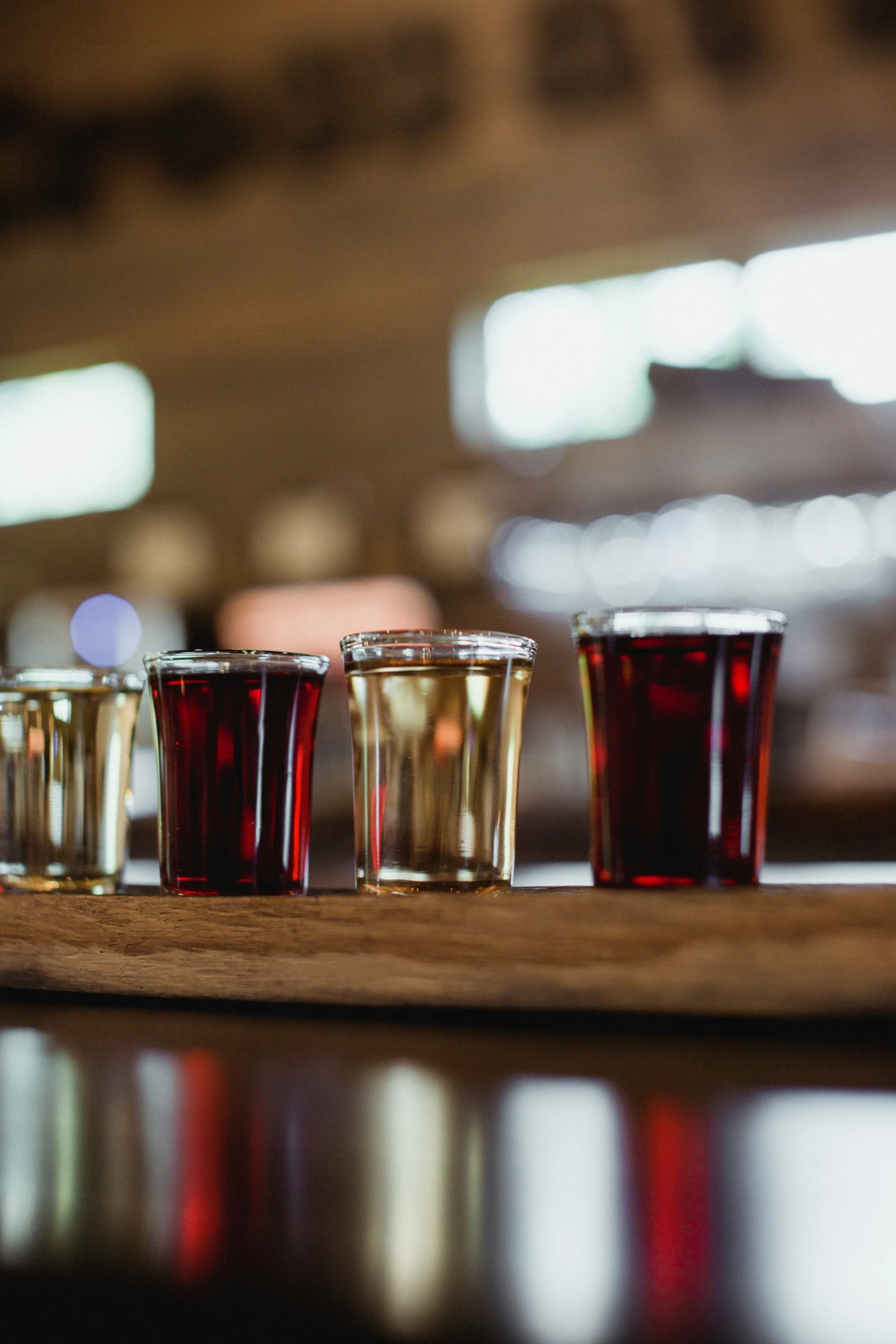 four glasses with different shapes on a wooden table