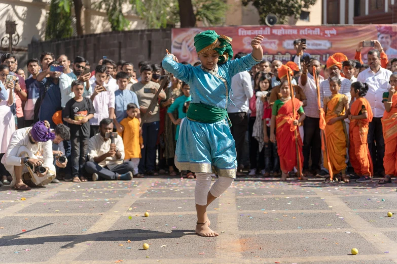 a boy dances in the street with a crowd watching