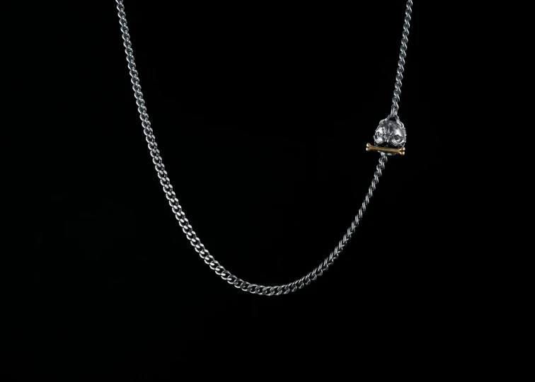 a silver and black necklace on a black background