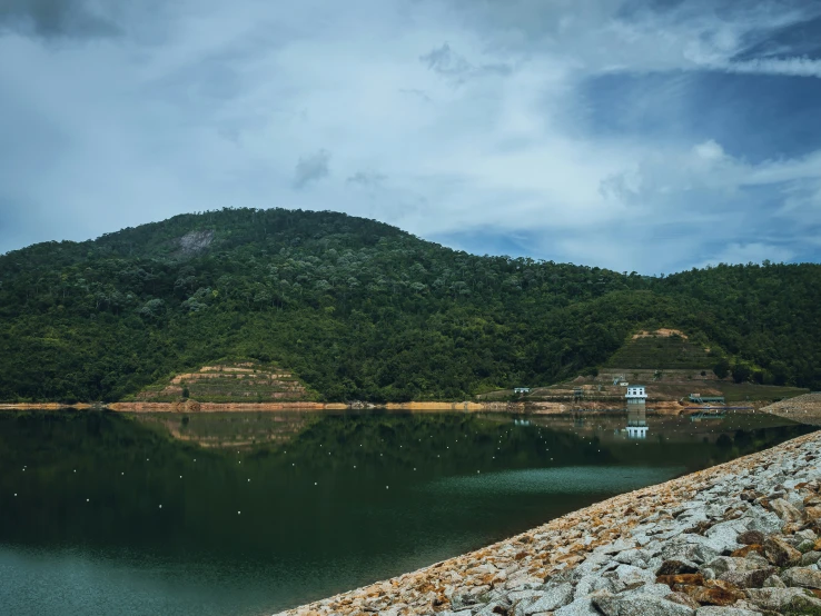 a lake surrounded by trees with a mountain in the background