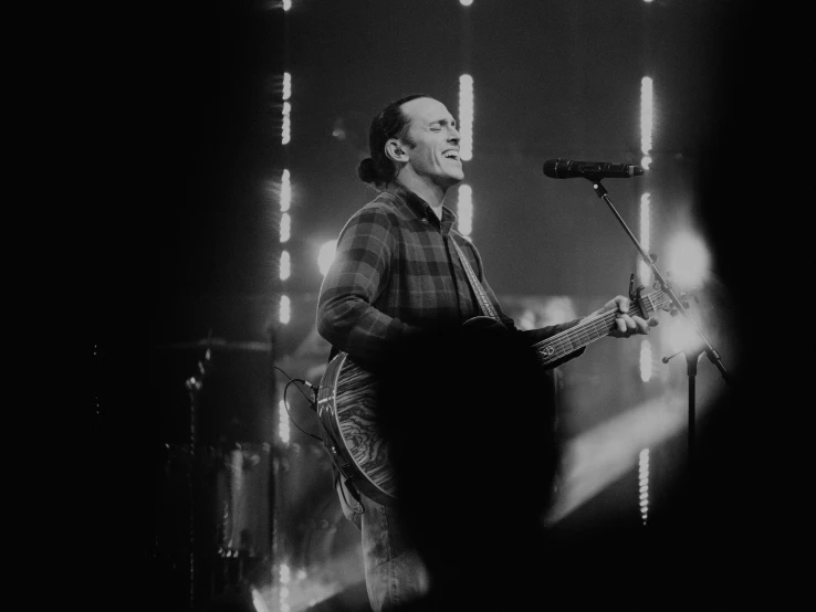 a man that is standing up with a guitar