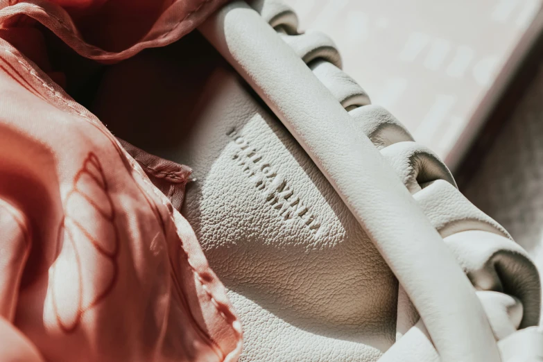 a close up of a pair of sneakers with pink scarf hanging over