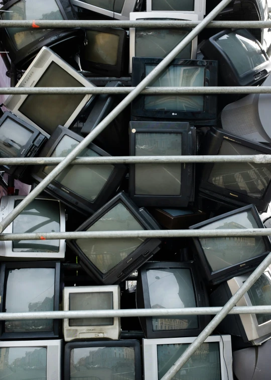 many old televisions and television sets all stacked together