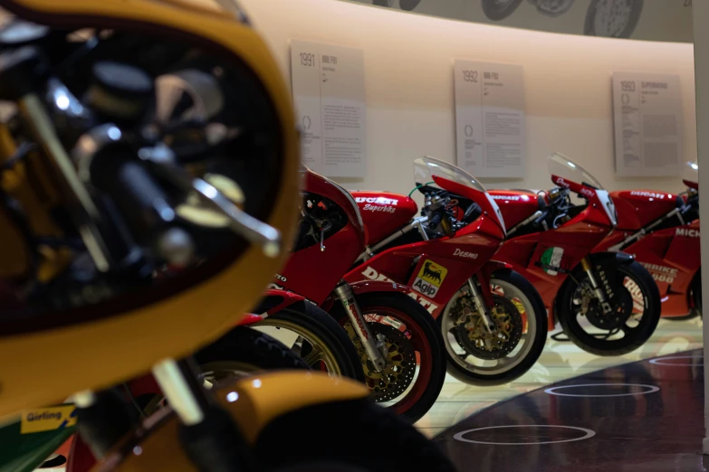 row of red motor bikes on display at museum