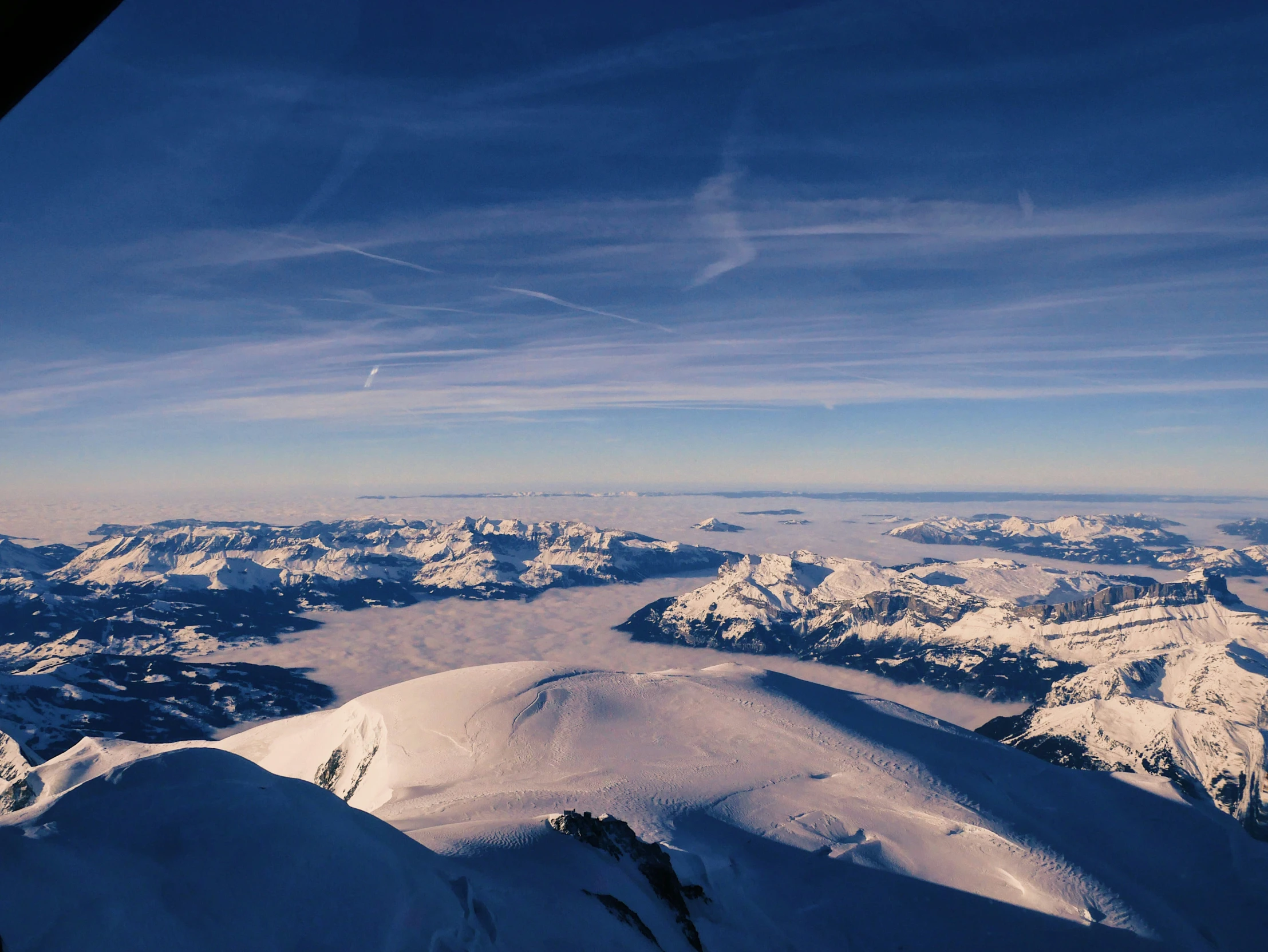 a plane flying over mountains covered with snow