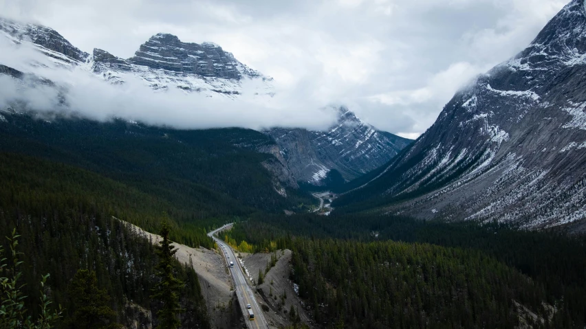 a truck traveling down a road between two mountains