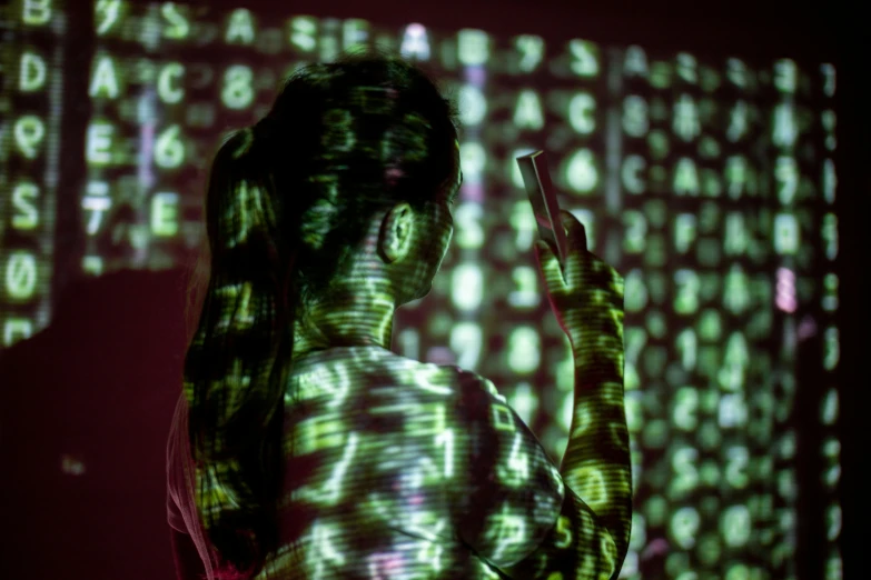 a woman standing in front of a screen with letters on it