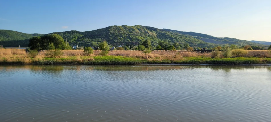 there is a large lake with a mountain in the background