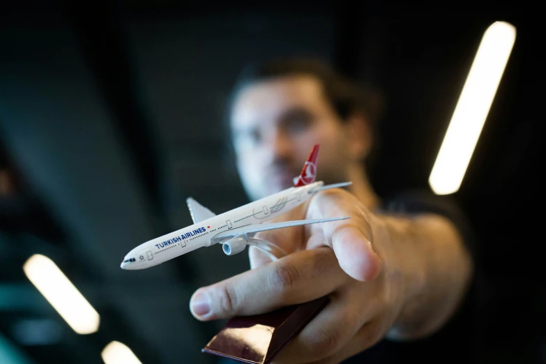 a person holds up a small model of a plane