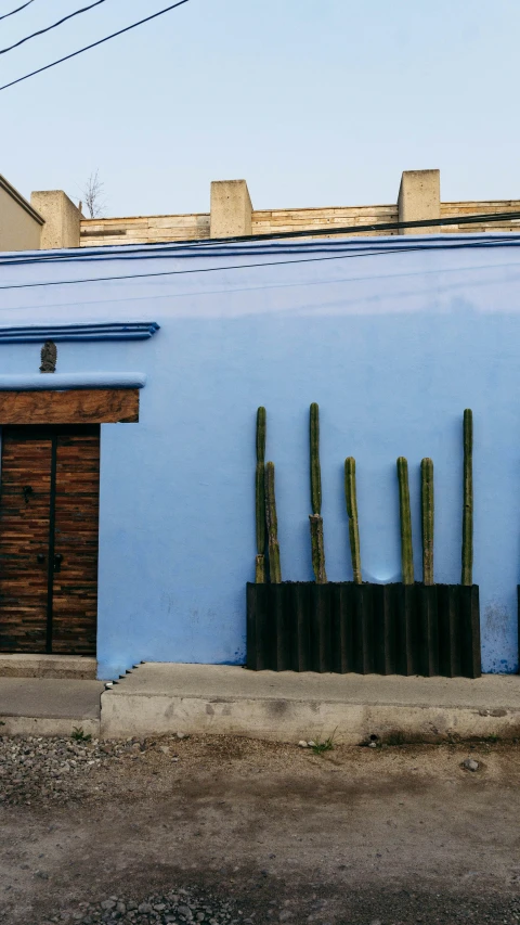 blue wall of a blue building with fence sticking out of it